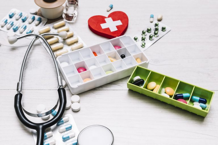 close-up-stethoscope-near-pills-heart-with-cross